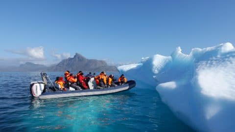 Schlauchboot mit Menschen an einer Eiskante